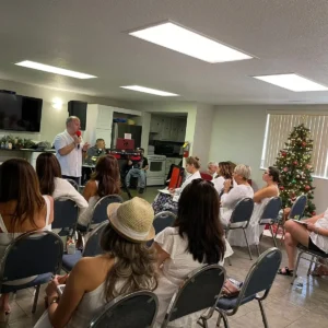 A group of people sitting in chairs and one person standing up.