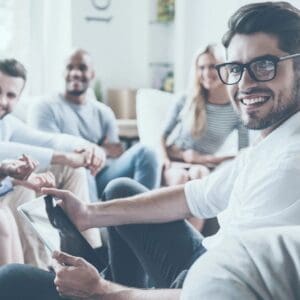 A group of people sitting around each other.