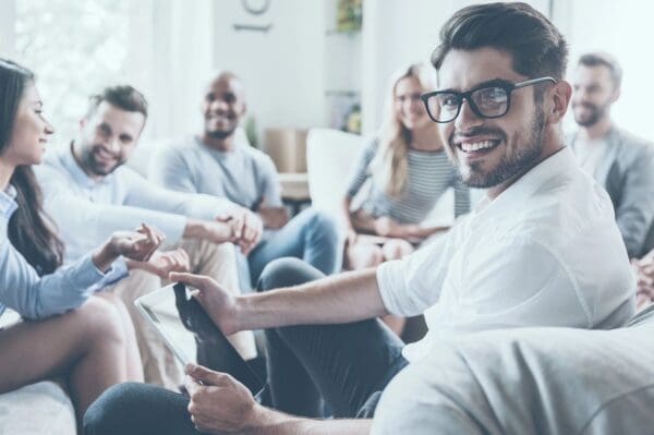 A group of people sitting around each other.